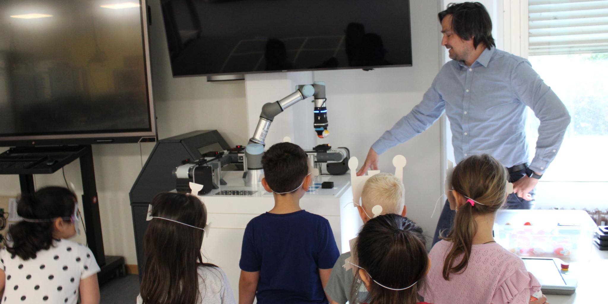Kinder gucken einem Roboterarm zu, der ein Überraschungsei transportiert. (c) Katholische KiTa gGmbH Koblenz Kinder gucken einem Roboterarm zu, der ein Überraschungsei transportiert.