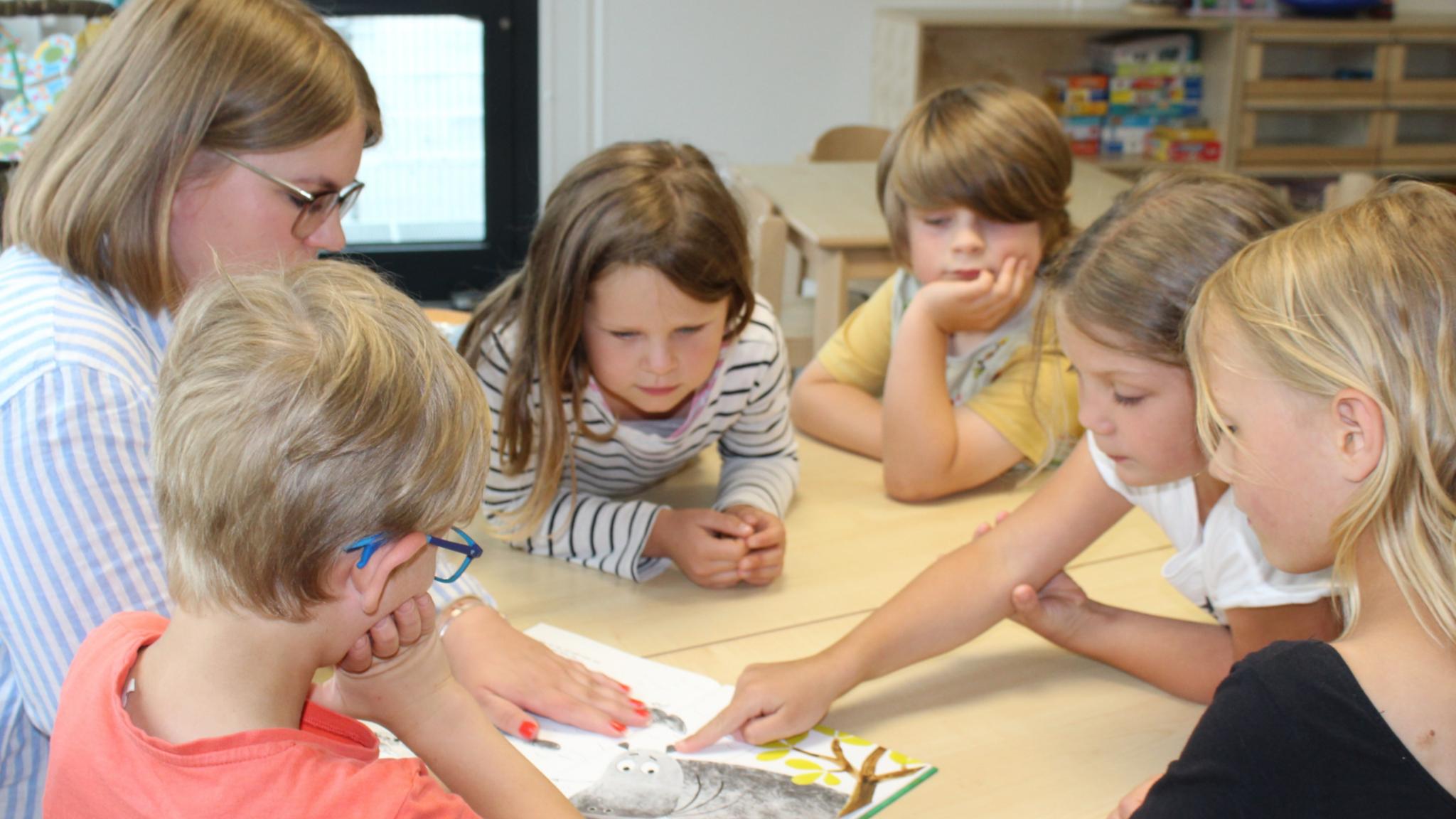 Die Vorschulkinder der katholischen Kita St. Pius besprechen gemeinsam ein Buch.